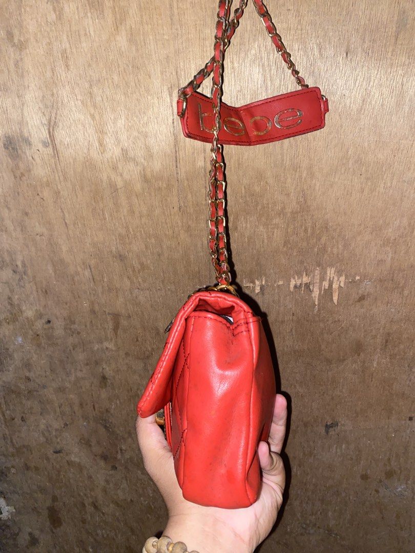 Red Bebe Quilted Shoulder Bag with Chain Strap (Category: Luxury Bags & Wallets) located in Caloocan City. Submitted by cleverwater.ba6482 (Listing ID 1467081210, Image 2). Description: - Brand: Bebe - Color: Bright red quilted - Hardware: Gold-tone chain strap with dangling logo letters and padded shoulder rest - Closure: Flap closure with decorative front clasp - Size: Compact, perfect for daily essentials - Condition: Good, with some visible m