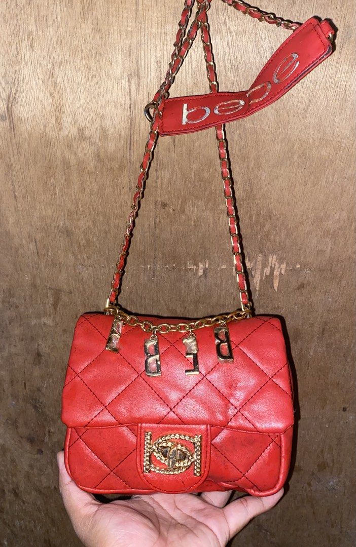 Red Bebe Quilted Shoulder Bag with Chain Strap (Category: Luxury Bags & Wallets) located in Caloocan City. Submitted by cleverwater.ba6482 (Listing ID 1467081210, Image 1). Description: - Brand: Bebe - Color: Bright red quilted - Hardware: Gold-tone chain strap with dangling logo letters and padded shoulder rest - Closure: Flap closure with decorative front clasp - Size: Compact, perfect for daily essentials - Condition: Good, with some visible m