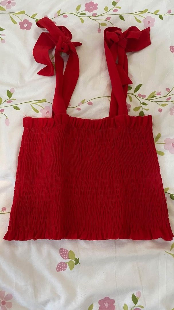 Red Smocked Crop Top with Tie Straps (Category: Sleeveless) located in Caloocan City. Submitted by lianarchiveee (Listing ID 1467092028, Image 1). Description: - Color: Bright Red - Fit: Fully smocked, stretchy material that flatters your figure - Straps: Adjustable self-tie shoulder straps - Details: Chic ruffle hem at the top and bottom edges - Styling: Pairs effortlessly with high-waisted jeans or skirts - Condition: Brand new / Excellent.