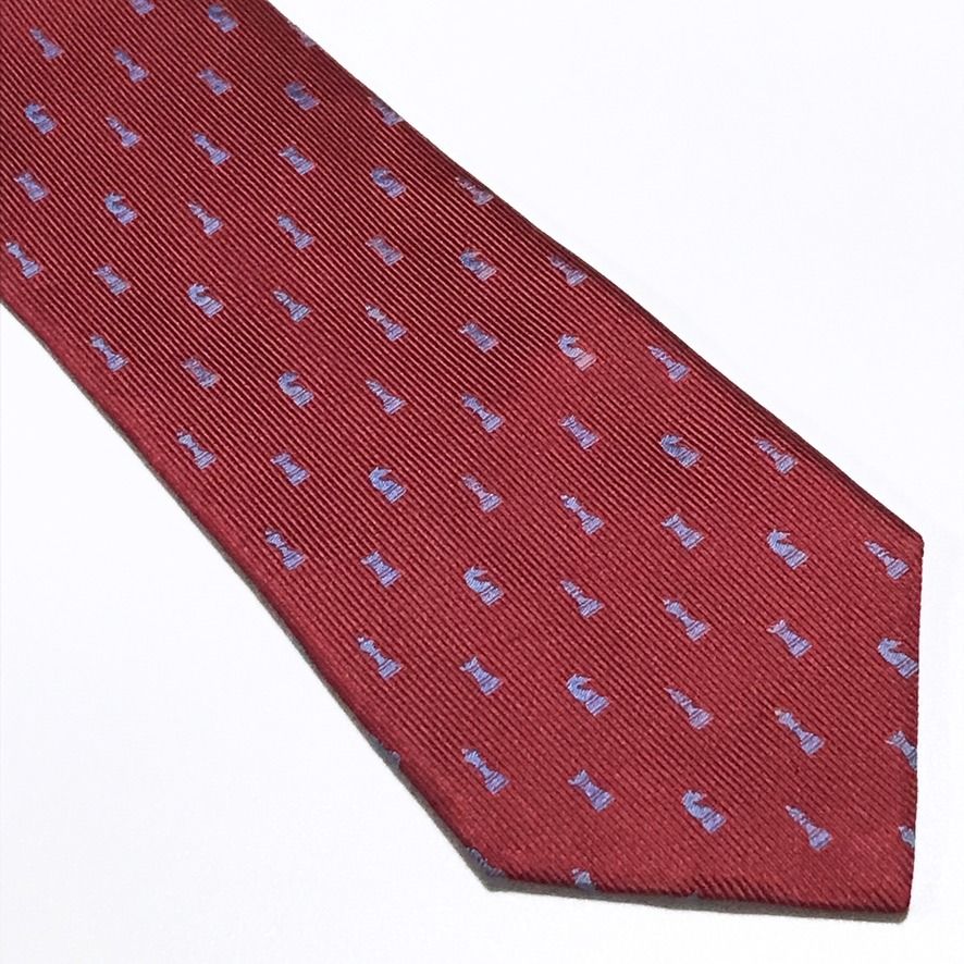 Renoma Chess PiscesTextured Ribbed Red Neck Tie (Category: Ties) located in Taguig. Submitted by retrogaze (Listing ID 1466998220, Image 2). Description: This 100% silk necktie by Renoma features a rich crimson red base woven with a pronounced vertical ribbed texture. The body is decorated with an orderly novelty pattern of miniature chess pieces—including kings, queens, rooks, knights, and bishops—woven in a contrasting periwinkle light blue sil