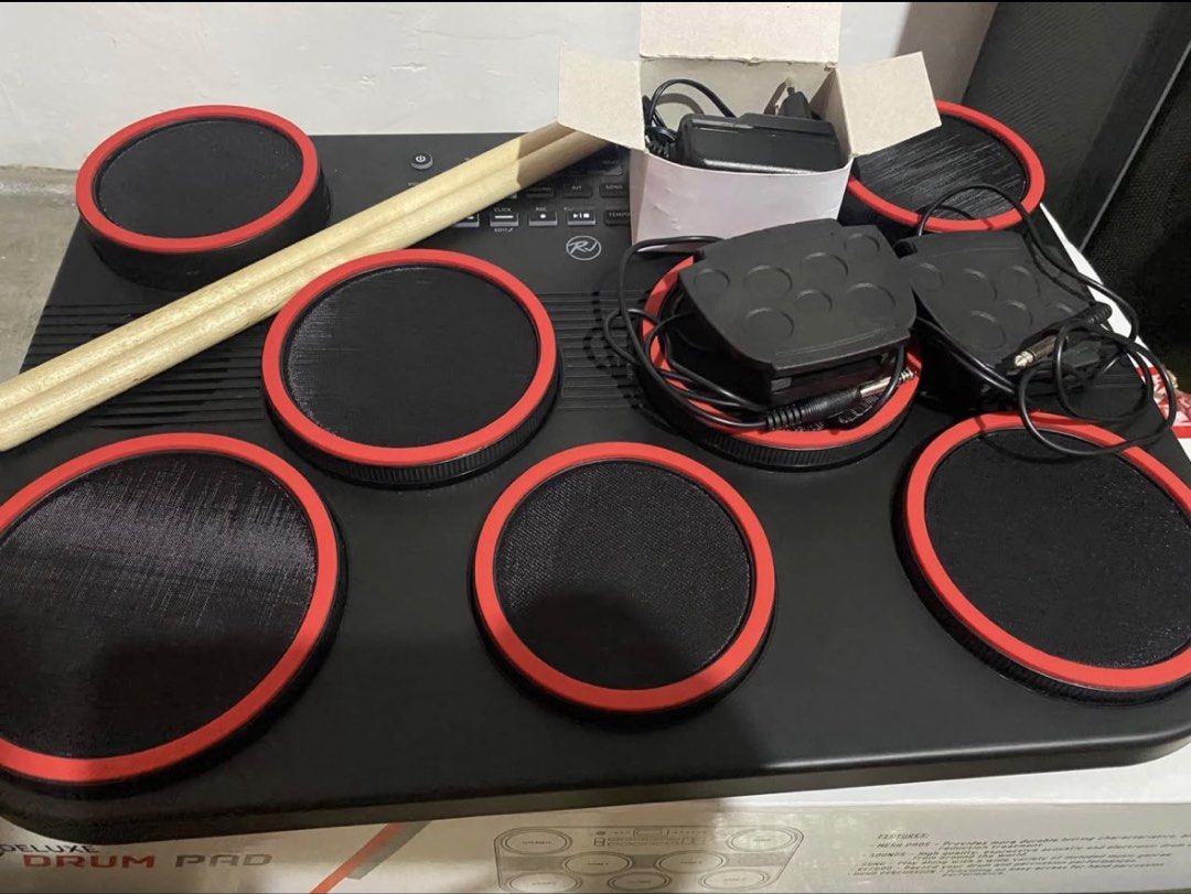 RJ Electronic Portable Drum Pad with Pedals and Sticks (Category: Musical Instruments) located in Paranaque City. Submitted by losangeles10 (Listing ID 1467086521, Image 2). Description: - Brand: RJ - Type: Portable electronic drum pad kit - Condition: Includes original box - Features: Realistic mesh pads with red rims, built-in speakers, and easy-to-use control panel - Inclusions: Drum unit, 2 pedals, power adapter, and wooden drum sticks - Perf
