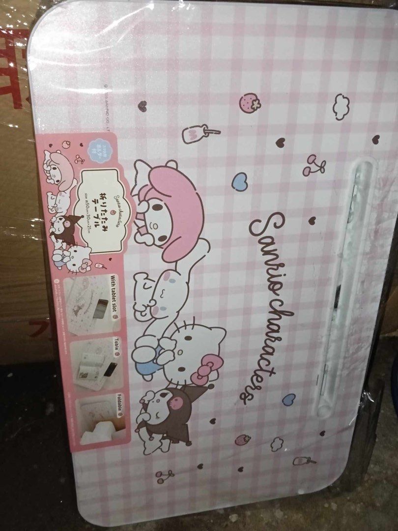 Sanrio Characters Foldable Table with Tablet Slot (Category: Tables & Sets) located in Manila. Submitted by janetecson05 (Listing ID 1467073165, Image 1). Description: - Authentic Sanrio characters design featuring My Melody, Cinnamoroll, Kitty, and Kuromi - Aesthetic pink and white checkered pattern - Built-in device slot for holding phones or tablets while studying or watching videos - Space-saving foldable legs for easy storage under the bed o