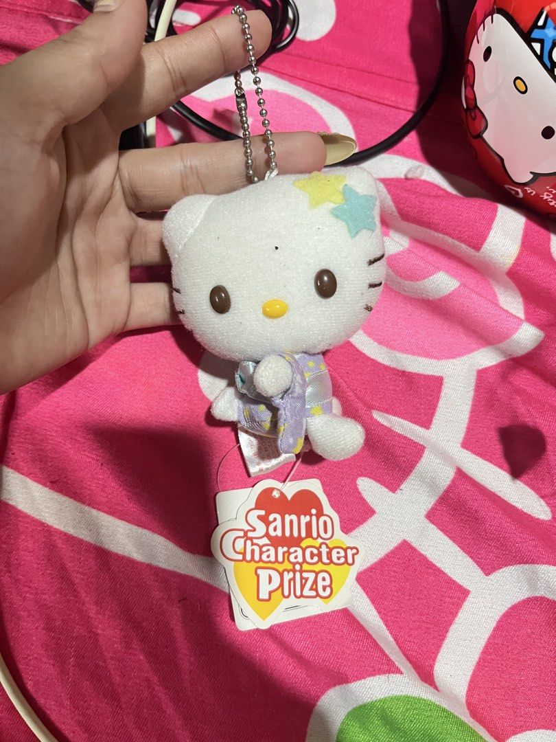 Sanrio Hello Kitty Character Prize Plush Keychain (Category: Plushies & Soft Toys) located in Manila. Submitted by janetecson05 (Listing ID 1467002572, Image 1). Description: - Authentic Sanrio Character Prize Kitty plush keychain - Features a cute white body with brown eyes, yellow nose, and felt stars near the ear - Wears a charming light purple patterned outfit - Complete with a silver ball chain and the original paper tag attached - Perfect f
