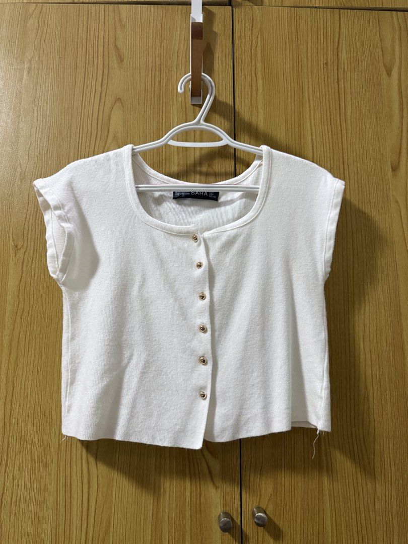 SARA White Knit Button-Up Crop Top (Category: Blouses) located in Quezon City. Submitted by cleaningmomma (Listing ID 1467058241, Image 1). Description: - Style: White knit crop top with short cap sleeves - Details: Square neckline and decorative gold-toned buttons - Material: Soft ribbed fabric with a great stretch - Measurements: ~16.5 inches in length, ~17inches across the chest - Versatility: Perfect basic for layering or warm-weather styling