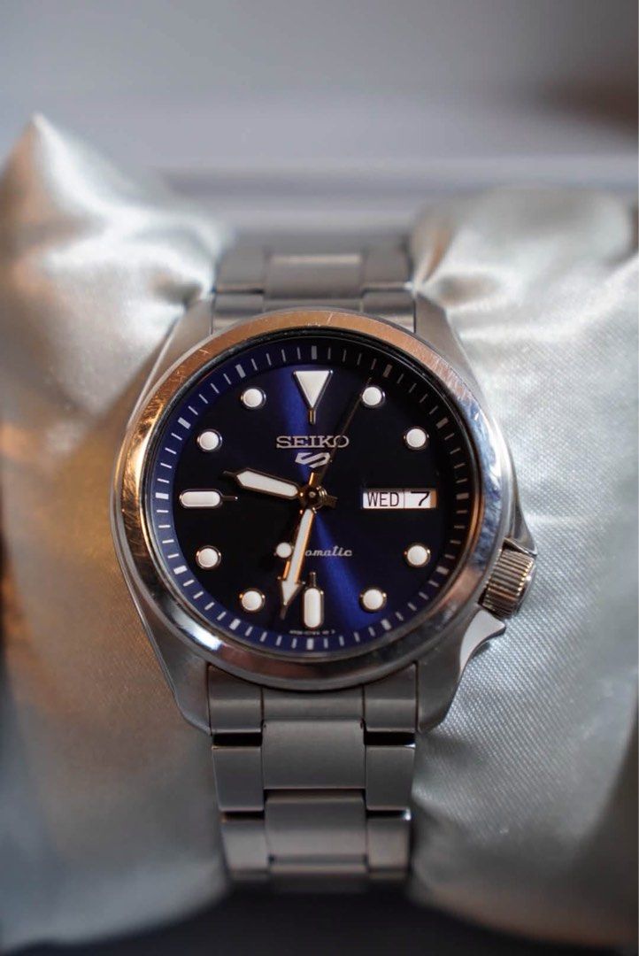 Seiko 5 SRPE53K1 (Category: Men's Watches) located in San Fernando. Submitted by andrewalex77489 (Listing ID 1467158362, Image 1). Description: - Model: Seiko 5 Automatic Watch - Dial: Stunning blue sunburst dial with luminous hands and hour markers - Case & Bracelet: Durable stainless steel case and matching metal bracelet - Features: Convenient day and date display at 3 o'clock, signature crown at 4 o'clock - Condition: Polished bezel has minor