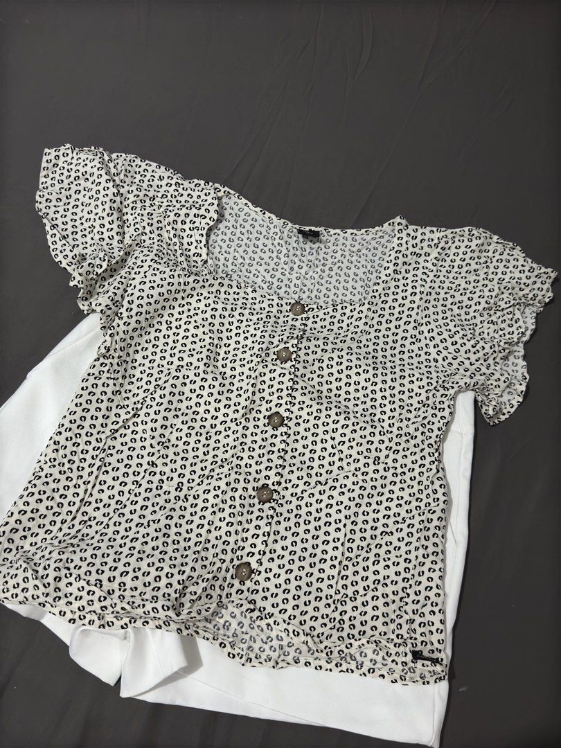 Short sleeve patterned blouse with buttons (Category: Blouses) located in Manila. Submitted by cleverturtle.1ace8b (Listing ID 1467042282, Image 2). Description: - Style: Casual everyday short sleeve blouse - Color/Pattern: Off-white with dense black geometric print - Details: Square neckline, ruffled sleeve edges, brown patterned front buttons - Material: Lightweight and breathable fabric, perfect for warm days - Condition: Brand new / Excellent