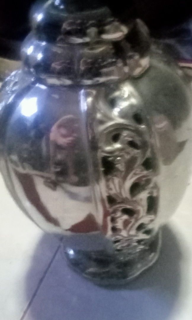 Silver Decorative Vase with Ornate Cutout Design (Category: Vases & Decorative Bowls) located in Paranaque City. Submitted by dimaguilaa94969 (Listing ID 1460054204, Image 3). Description: - Beautiful silver vase - Features an intricate cutout pattern around the middle - Ribbed detail on the neck - Classic urn shape with a flared opening - Ideal for displaying flowers or as a standalone decorative piece - Adds a touch of elegance to any room.
