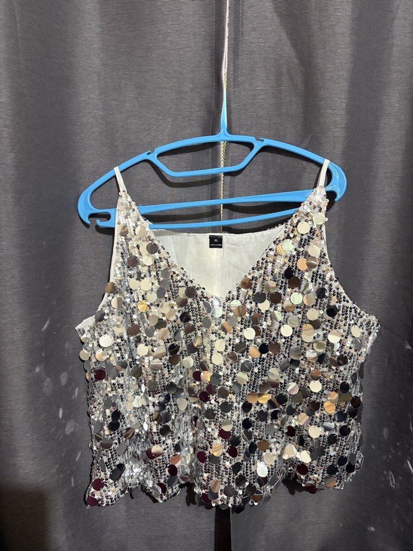 Silver Sequin Cami Tank Top Size XL (Category: Sleeveless) located in Manila. Submitted by greengrapesrgreat (Listing ID 1466993551, Image 1). Description: - Style: Silver sequin cami top with V-neckline and thin spaghetti straps - Size: XL - Features: Fully covered in shiny round sequins with comfortable white lining - Perfect for: Parties, clubbing, music festivals, and night outs - Condition: Great statement piece that stands out under lights 