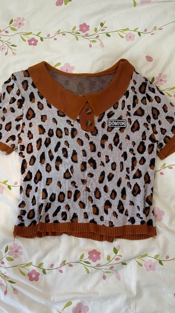 SOMTOR Leopard Print Knitted Polo Crop Top (Category: Sleeveless) located in Caloocan City. Submitted by lianarchiveee (Listing ID 1467091700, Image 1). Description: - Style: Short-sleeve cropped knit top - Pattern: Bold all-over leopard print with contrast brown collar, button placket, and hem - Details: Features a small SOMTOR patch on the left chest - Material: Soft, comfortable textured knit - Fit: Cropped length, pairs great with high-waiste