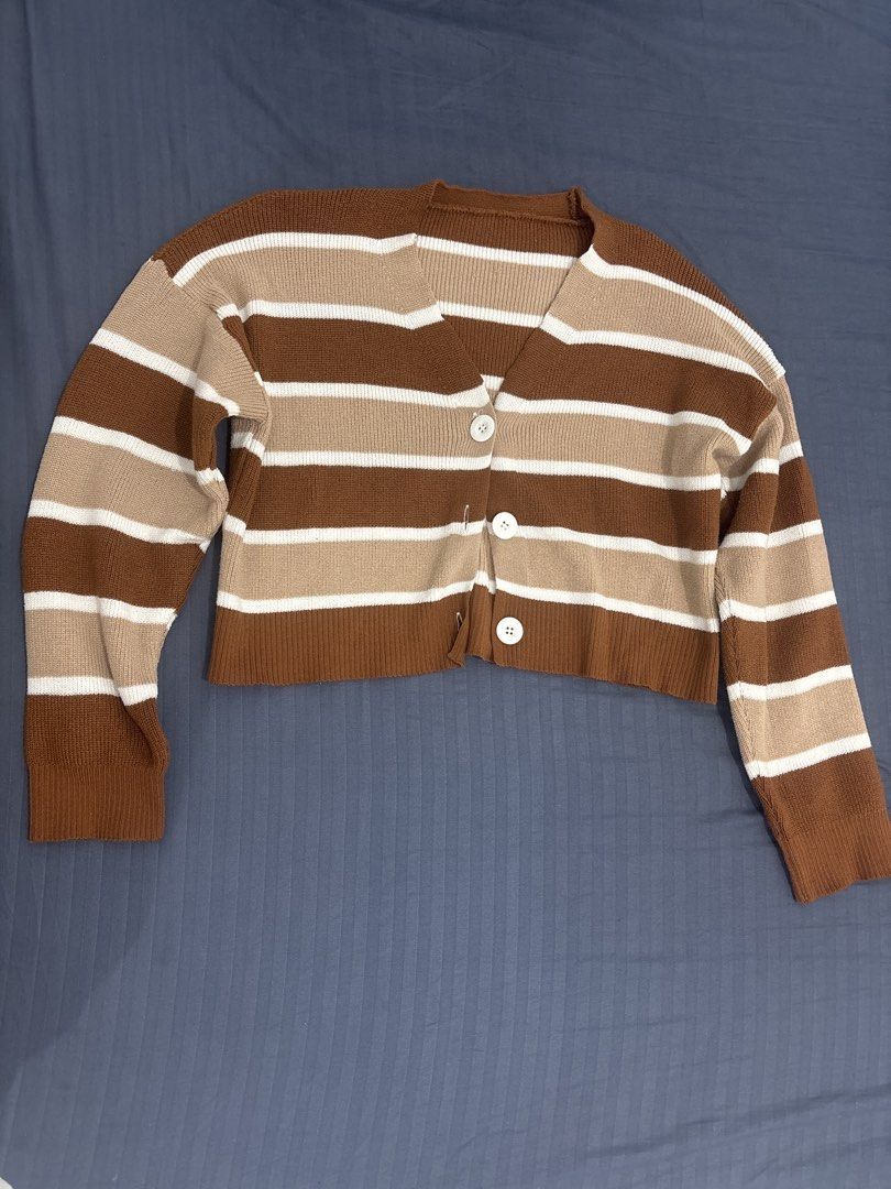 Striped Brown V-Neck Knit Cardigan (Category: Coats, Jackets and Outerwear) located in Makati City. Submitted by blueberrylime (Listing ID 1466976222, Image 1). Description: - Color: Brown, tan, and white horizontal stripes - Style: Cropped fit V-neck cardigan - Details: Three white front buttons with soft ribbed cuffs and hem - Material & Fit: Soft, cozy knit great for layering in cooler weather - Versatility: Neutral tones that easily match wit