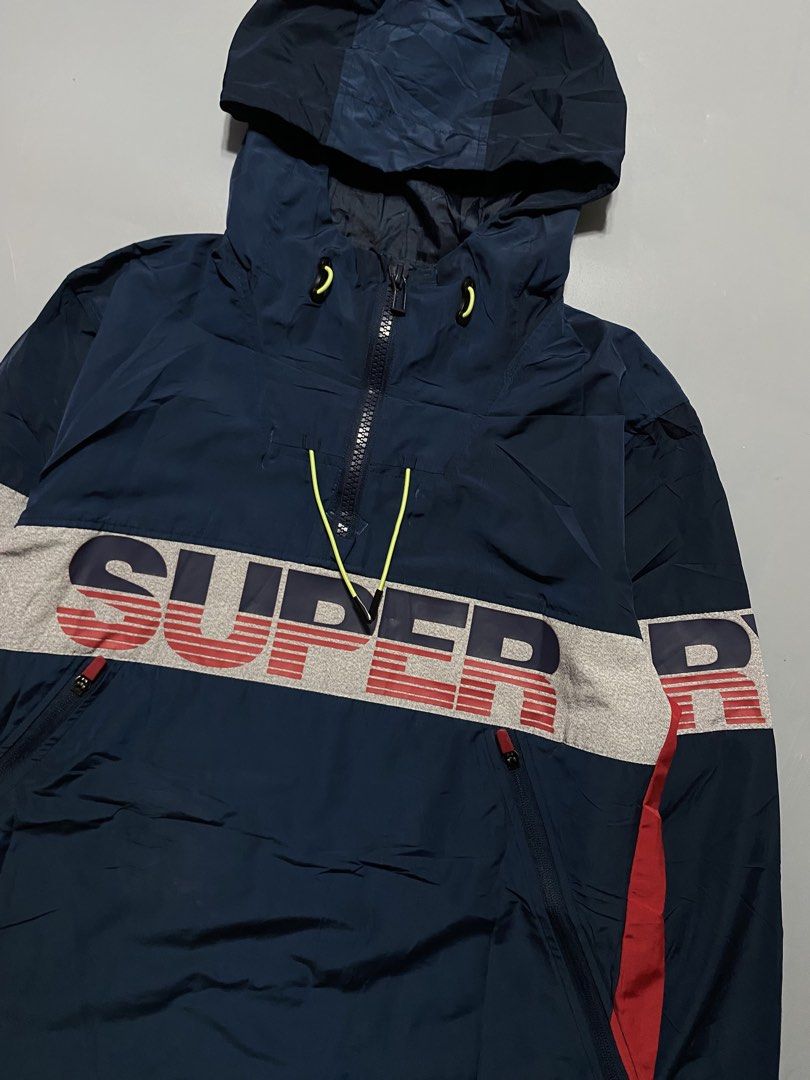 Superdry Hooded Windbreaker Jacket Navy Blue (Category: Coats, Jackets and Outerwear) located in Manila. Submitted by delunakenn94368 (Listing ID 1467141643, Image 2). Description: - Brand: Superdry waterproof - Type: Men's Sport Hooded Jacket / Windbreaker - Color: Navy blue with grey chest panel, red side panels, and bold branding - Features: Neon yellow drawstrings, matching sleeve details, and front zip pockets - Fit: Regular fit - Condition: