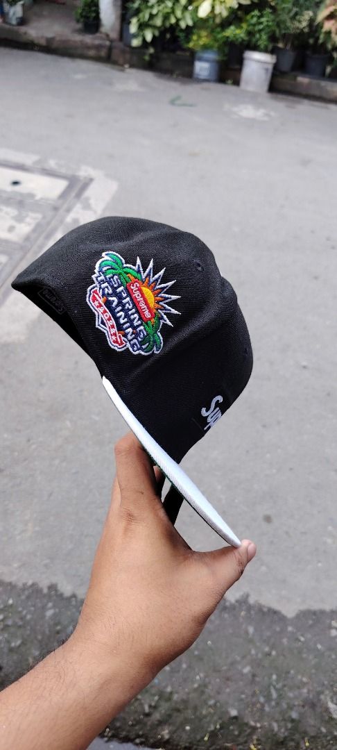 Supreme x New Era Spring Training Fitted Hat Black White (Category: Caps & Hats) located in Paranaque City. Submitted by easymommygo (Listing ID 1466979404, Image 3). Description: - Brand: Supreme x New Era - Color: Black and White with Green Under Visor - Size: 7 1/2 - Details: Embroidered Supreme box logo on front, New Era flag on side, special Spring Training patch on the other - Condition: Clean stitching all around, classic streetwear piece.