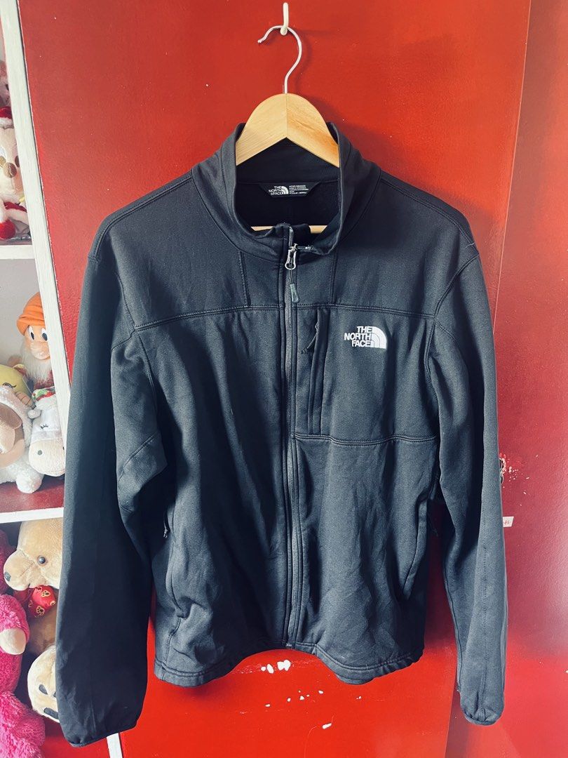 The North Face Men's Apex Bionic Softshell Jacket in black. (Category: Activewear) located in Quezon City. Submitted by wacpon_061972 (Listing ID 1446062143, Image 1). Description: This black The North Face softshell jacket features a zippered chest pocket and embroidered branding. (W-23/L-28).