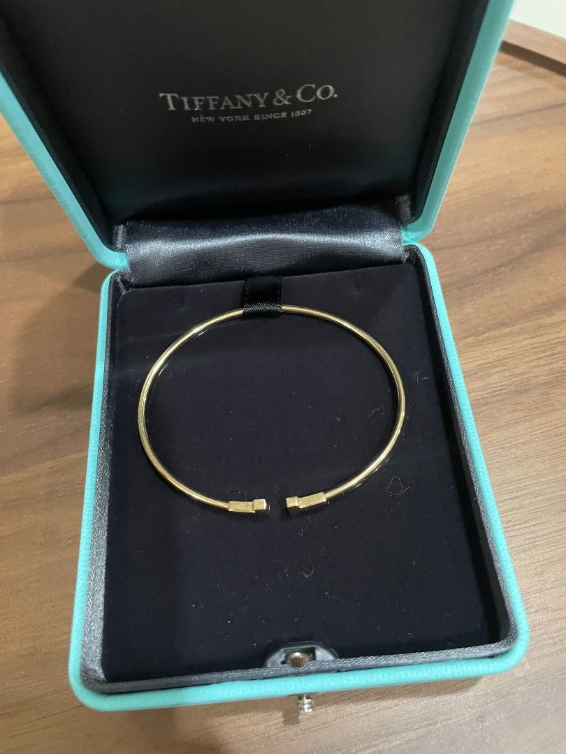 Authentic Tiffany & Co. T Wire Bracelet Gold (Category: Bracelets) located in Quezon City. Submitted by yenggaytot76 (Listing ID 1467099857, Image 1). Description: - Authentic Gold Tiffany & Co. wire bracelet - Iconic T-end design with minimalist open-cuff style - Easy to slip on and off the wrist - Includes original Tiffany turquoise presentation box with black interior lining - Classic and timeless piece perfect for daily wear or gifting.