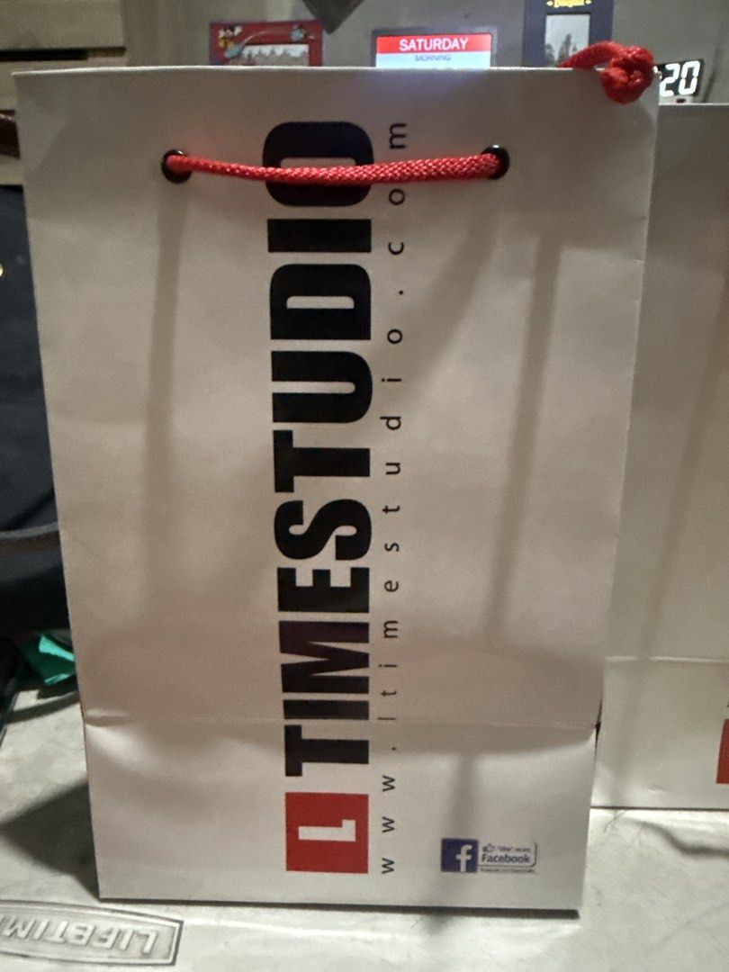 Timestudio Paper Shopping Bag Gift Bag (Category: Tote Bags) located in Manila. Submitted by babybulilit (Listing ID 1466976889, Image 2). Description: - white Timestudio paper bags - Features a bold black vertical logo - Equipped with durable red braided rope handles and metal eyelets - Sturdy folded paper construction - Ideal for gifts, retail shopping, or special occasions.