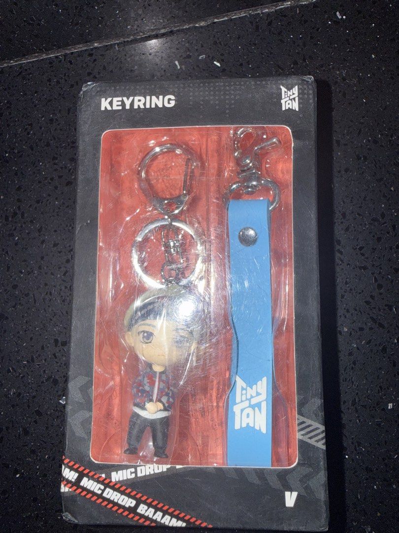 TinyTAN V Mic Drop Keyring (Category: Character Goods) located in Marikina City. Submitted by culose (Listing ID 1466990530, Image 1). Description: - Authentic BTS TinyTAN V keyring in Mic Drop outfit - Brand new and sealed in original box - Includes mini figure with metal split rings - Comes with a stylish blue leather strap featuring the TinyTAN logo and metal clip - Perfect for ARMY collectors and everyday use.
