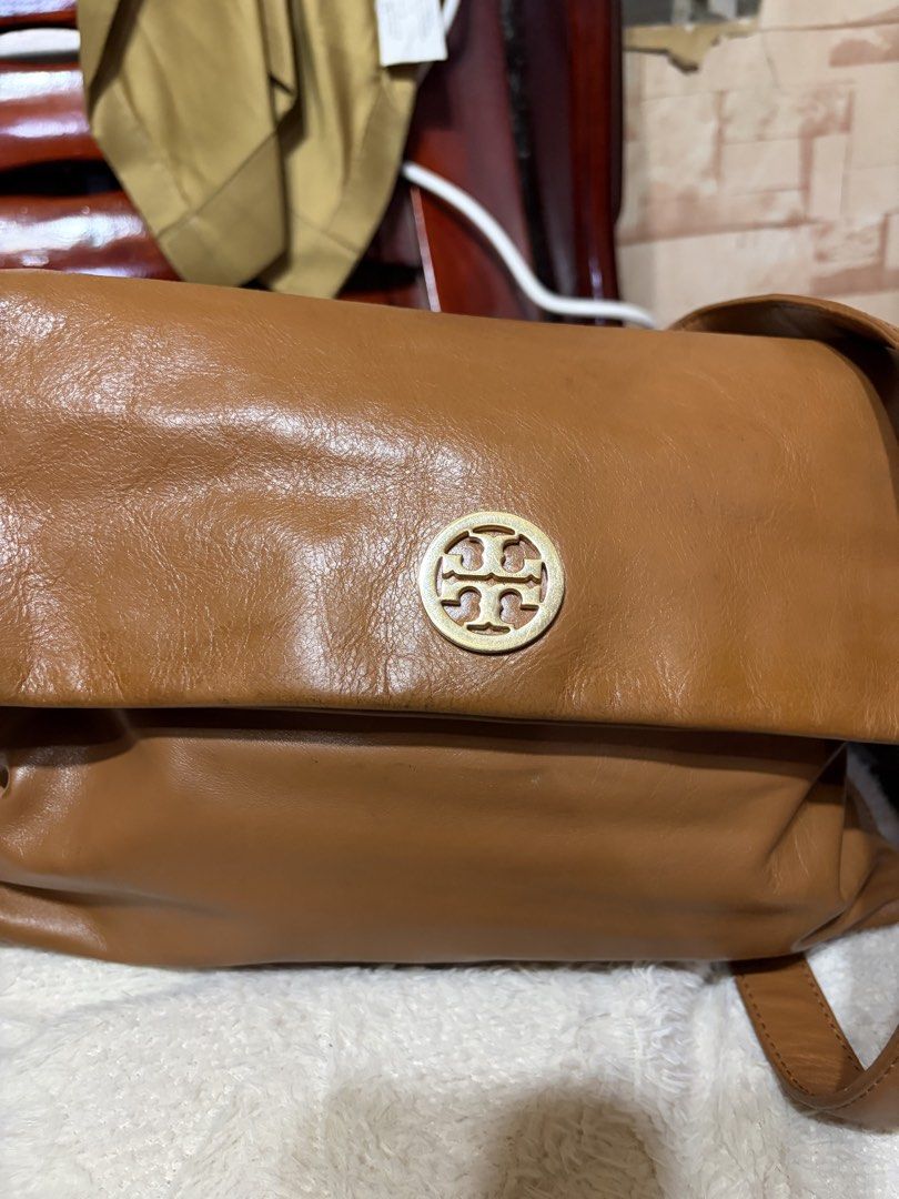 Tory Burch brown leather shoulder bag with gold hardware (Category: Luxury Bags & Wallets) located in Manila. Submitted by lynnalec25 (Listing ID 1467146102, Image 3). Description: - Brand: Tory Burch - Material: Genuine brown leather with light fabric lining - Design: Foldover flap with iconic gold-tone double T logo medallion - Strap: Adjustable strap with secure metal hardware - Interior: Roomy main compartment with a zippered pocket and logo 