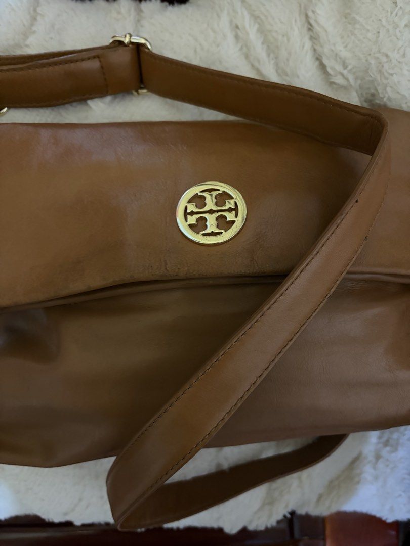 Tory Burch brown leather shoulder bag with gold hardware (Category: Luxury Bags & Wallets) located in Manila. Submitted by lynnalec25 (Listing ID 1467146102, Image 2). Description: - Brand: Tory Burch - Material: Genuine brown leather with light fabric lining - Design: Foldover flap with iconic gold-tone double T logo medallion - Strap: Adjustable strap with secure metal hardware - Interior: Roomy main compartment with a zippered pocket and logo 