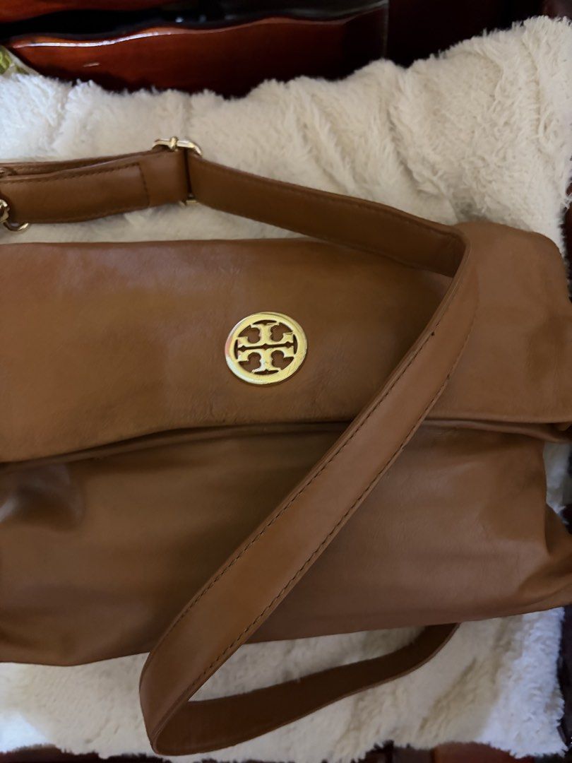 Tory Burch brown leather shoulder bag with gold hardware (Category: Luxury Bags & Wallets) located in Manila. Submitted by lynnalec25 (Listing ID 1467146102, Image 1). Description: - Brand: Tory Burch - Material: Genuine brown leather with light fabric lining - Design: Foldover flap with iconic gold-tone double T logo medallion - Strap: Adjustable strap with secure metal hardware - Interior: Roomy main compartment with a zippered pocket and logo 