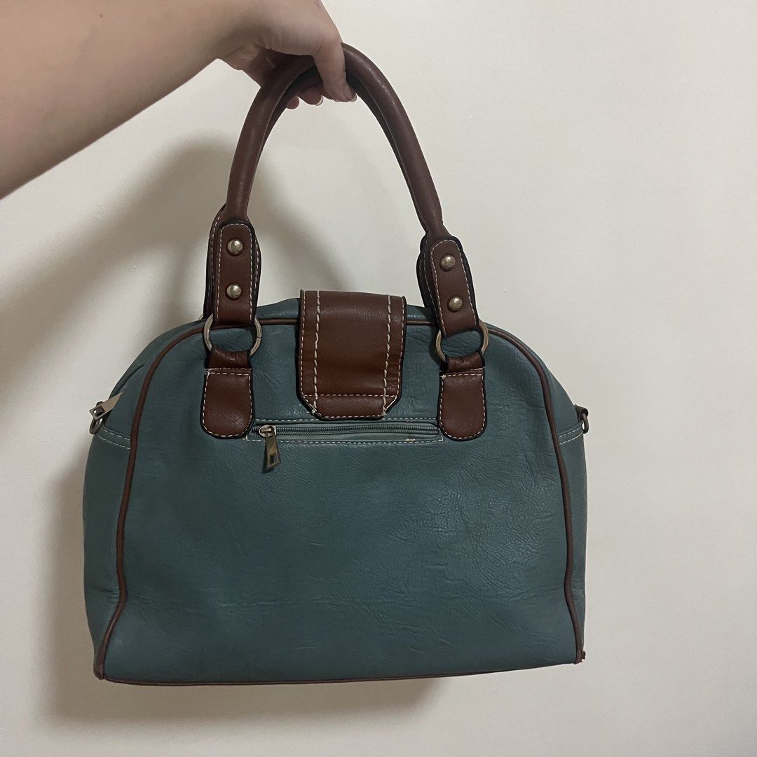Tory Burch Two-Tone Leather Handbag Teal Brown (Category: Luxury Bags & Wallets) located in Paranaque City. Submitted by bossique (Listing ID 1467090827, Image 3). Description: - NGA - Storage: Secure front magnetic flap closure and easy-access back zipper pocket - Handles: Double top handles (note: minor cracking along the edge, as shown in the last photo) - Condition: Check images for issues - J&T / Lala - handled by buyer.