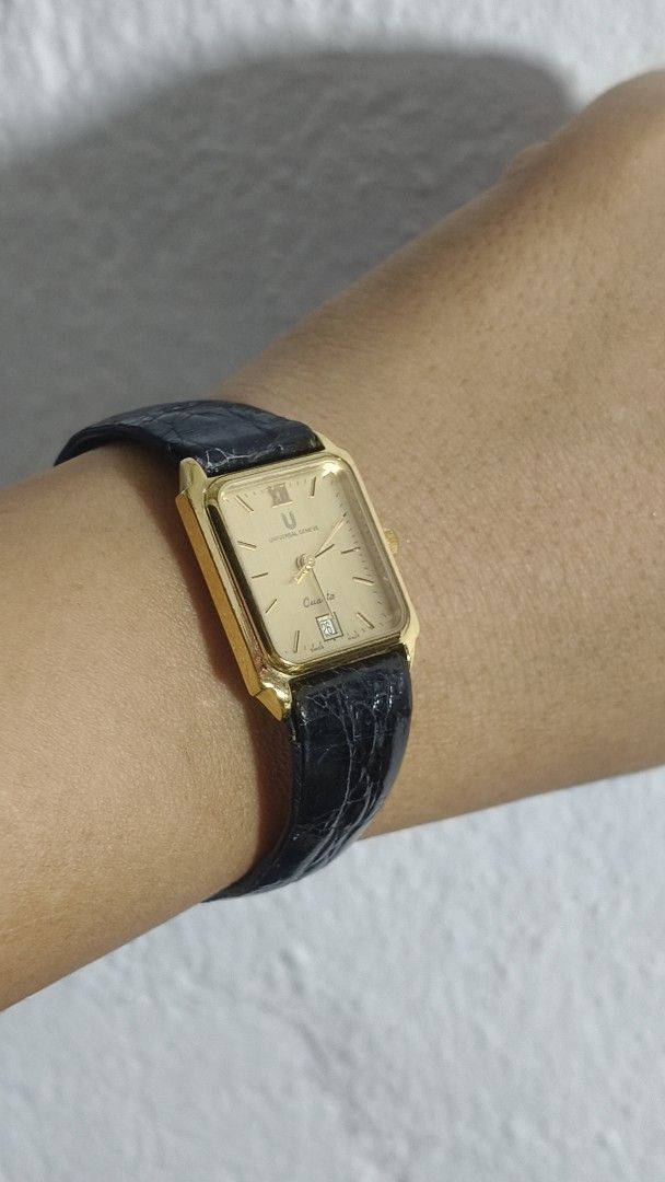 Universal Geneve Quartz Gold toneWatch Black Leather Strap (Category: Women's Watches) located in Taguig. Submitted by mercyeugen28914 (Listing ID 1467031414, Image 2). Description: - Brand: Universal Geneve - Style: Vintage dress watch with gold-tone rectangular case - Dial: Classic champagne dial featuring Roman numeral at 12 and date window at 6 o'clock - Movement: Quartz movement - Strap: Original black leather strap with embossed texture and