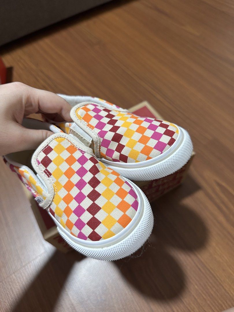 Vans Slip-On toddler (Category: Babies & Kids Fashion) located in Manila. Submitted by nolanandpio (Listing ID 1467031125, Image 2). Description: - Brand: Vans - Style: Slip-on sneakers in retro rainbow checkerboard (Orange, yellow, pink, and burgundy) - Size: 10 Toddler - Features: Elastic side gore panels and heel pull tabs for easy on and off - Soles: White rubber with iconic red 'Off The Wall' heel logo - Packaging: Original box included - Pe
