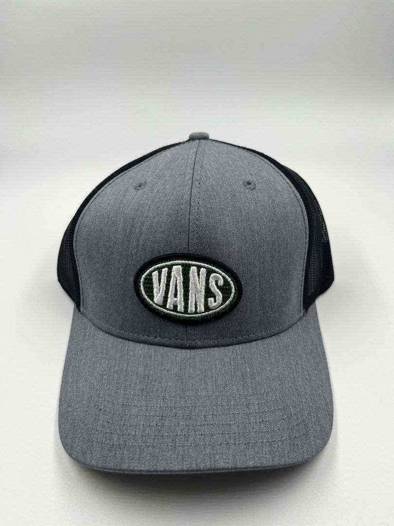 Vans Trucker Cap (Category: Caps & Hats) located in Manila. Submitted by five_gallery (Listing ID 1467167265, Image 1). Description: - Brand: Vans - Color: Grey and black - Design: Structured front panel with green and white embroidered Vans logo patch - Back: Breathable black mesh with adjustable snapback closure - Brim: Curved - Condition: Excellent, clean fabric with zero fading or stains.
