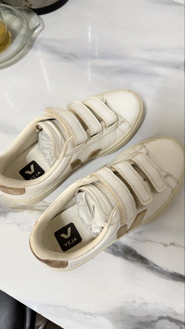 Veja Esplar White Gold Velcro Sneakers (Category: Sneakers) located in Valenzuela. Submitted by ruichi080607 (Listing ID 1467166350, Image 2). Description: - Brand: Veja - Material: Premium white leather - Details: Gold metallic side logo and heel tab with embossed branding - Closure: Triple hook-and-loop velcro strap - Sole: Flat rubber sole - Fit: True to size - Condition/Style: Great casual daily wear pair.