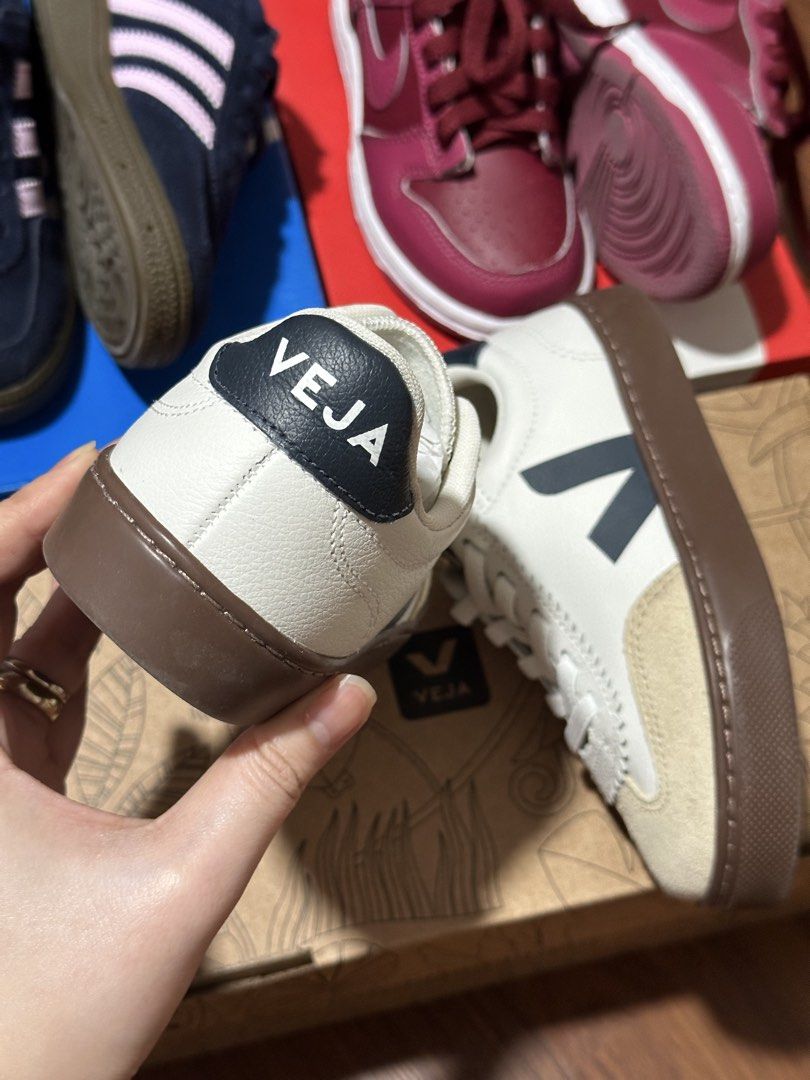 Veja kids (Category: Babies & Kids Fashion) located in Manila. Submitted by nolanandpio (Listing ID 1467030769, Image 2). Description: - Brand: Veja - Color: White leather with dark navy logo, heel tab, and gum brown sole - Material: Smooth leather upper with textured suede toe caps - Features: Convenient elastic laces (slip-on ease) and distinctive zigzag stitching along the eyelets - Condition: Excellent, clean design ready for your everyday OO
