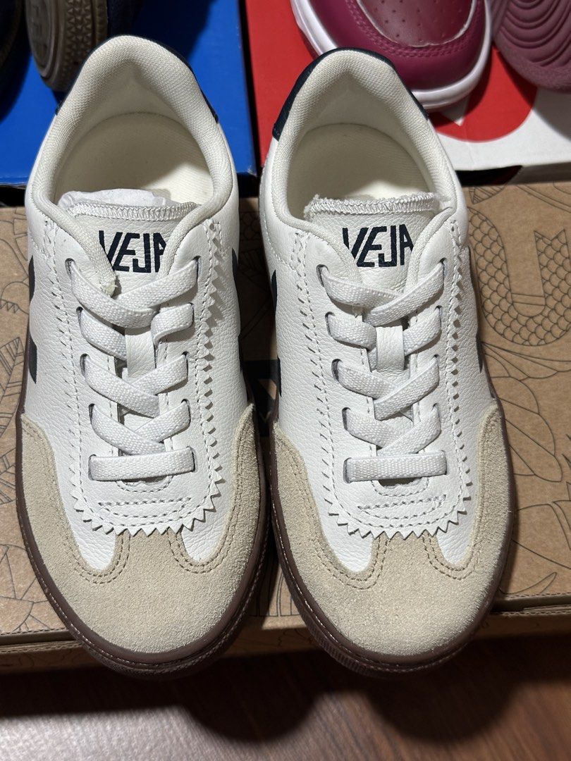 Veja kids (Category: Babies & Kids Fashion) located in Manila. Submitted by nolanandpio (Listing ID 1467030769, Image 3). Description: - Brand: Veja - Color: White leather with dark navy logo, heel tab, and gum brown sole - Material: Smooth leather upper with textured suede toe caps - Features: Convenient elastic laces (slip-on ease) and distinctive zigzag stitching along the eyelets - Condition: Excellent, clean design ready for your everyday OO