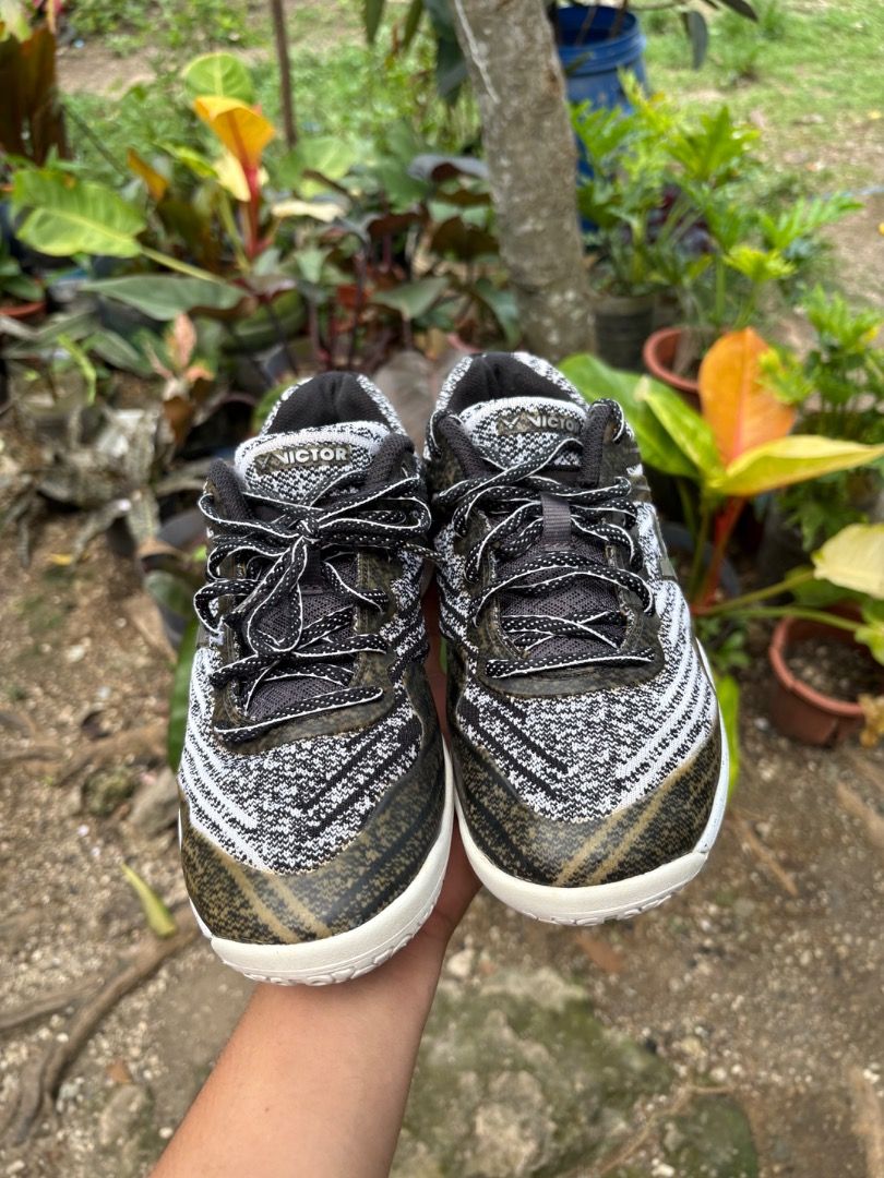 Victor Black White Athletic Sneakers (Category: Sneakers) located in Danao, Cebu. Submitted by kentoy25 (Listing ID 1467027082, Image 2). Description: - Brand: Victor athletic shoes - Colorway: Black, white, and grey pattern with stylish metallic olive green accents near the toe and sides - Upper: Breathable textured knit material with black laces and a padded collar for extra comfort - Outsole: Durable white rubber outsole with cool dark speckle