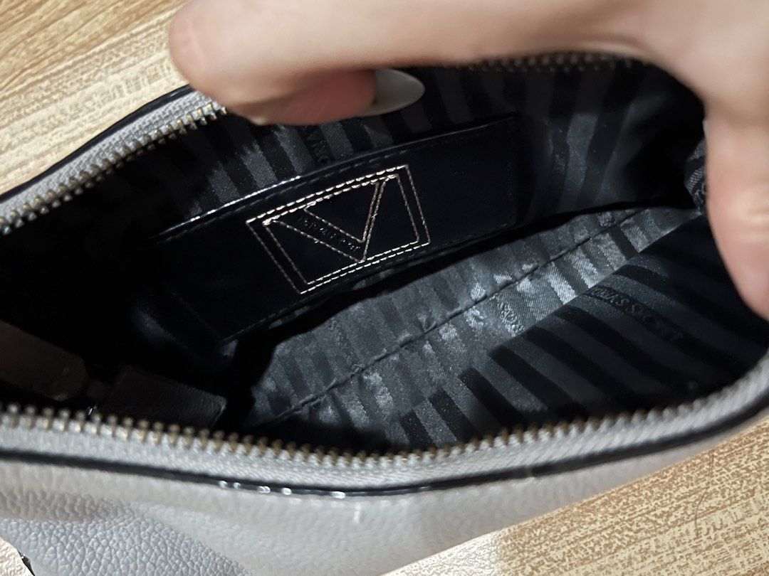 Victoria's Secret Grey Shoulder Bag (Category: Shoulder Bags) located in Manila. Submitted by angelinama02203 (Listing ID 1467123583, Image 3). Description: - Brand: Victoria's Secret - Material: Grey faux leather with dark hardware - Straps: Includes a dark chain strap plus a brand-new detachable long strap still in original plastic - Closure: Secure zip closure with branded pull tab - Interior: Classic striped lining with Victoria's Secret logo