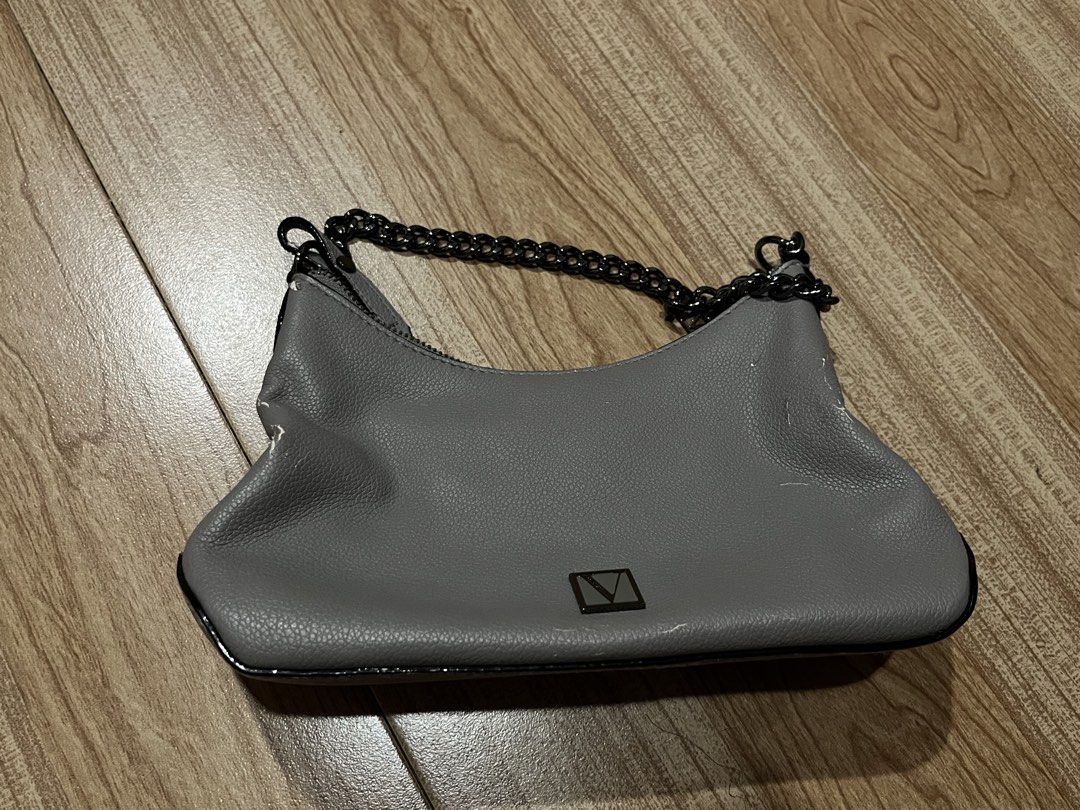 Victoria's Secret Grey Shoulder Bag (Category: Shoulder Bags) located in Manila. Submitted by angelinama02203 (Listing ID 1467123583, Image 1). Description: - Brand: Victoria's Secret - Material: Grey faux leather with dark hardware - Straps: Includes a dark chain strap plus a brand-new detachable long strap still in original plastic - Closure: Secure zip closure with branded pull tab - Interior: Classic striped lining with Victoria's Secret logo