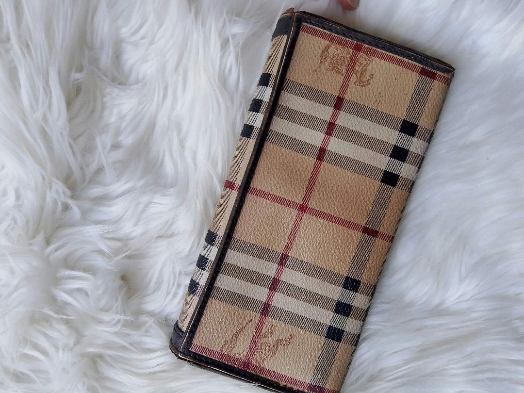 Vintage Burberry Check Long Wallet (Category: Wallets & Card holders) located in Midsayap. Submitted by purse_gedo (Listing ID 1466998533, Image 2). Description: Burberry long wallet with iconic check print and equestrian knight logo debossed on the front. Dark brown leather trim and interior lining. Snap button closure. Multiple card slots, cash compartments, and a zippered coin pocket inside. Stamped Made in Italy on the interior leather..