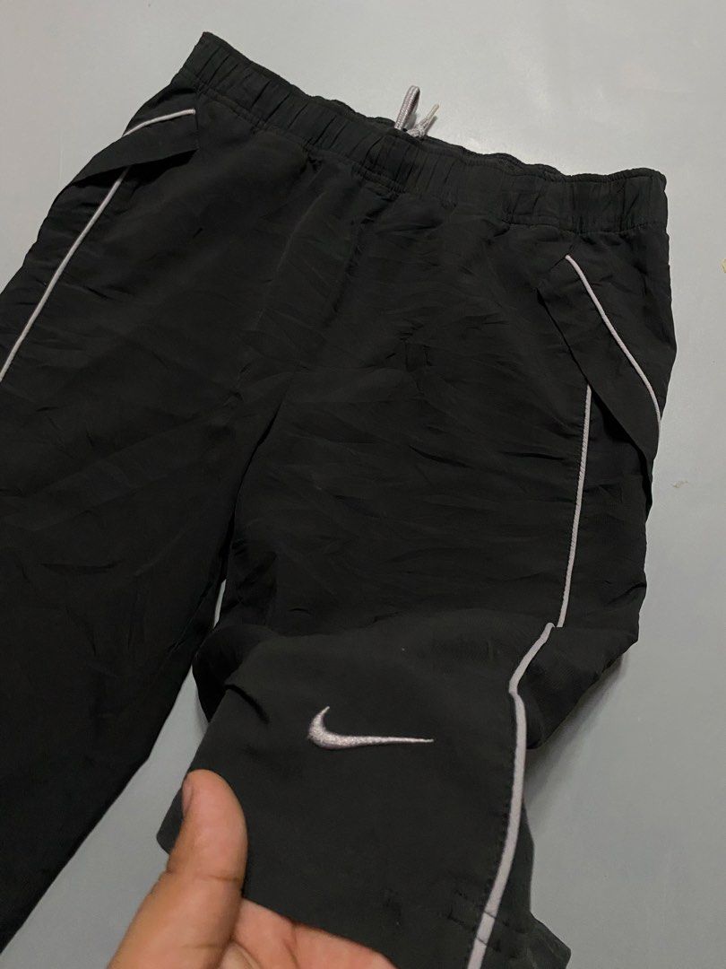 vintage Nike Black Nylon capri (Category: Shorts) located in Manila. Submitted by delunakenn94368 (Listing ID 1467141428, Image 2). Description: - Brand: Nike - Color: Black with white piping and logo - Size: Medium - Material: Lightweight nylon - Features: Elastic waistband with grey drawstring, contrasting front pockets, small embroidered white swoosh - Condition/Details: Clean interior tags, perfect for casual wear or workouts.