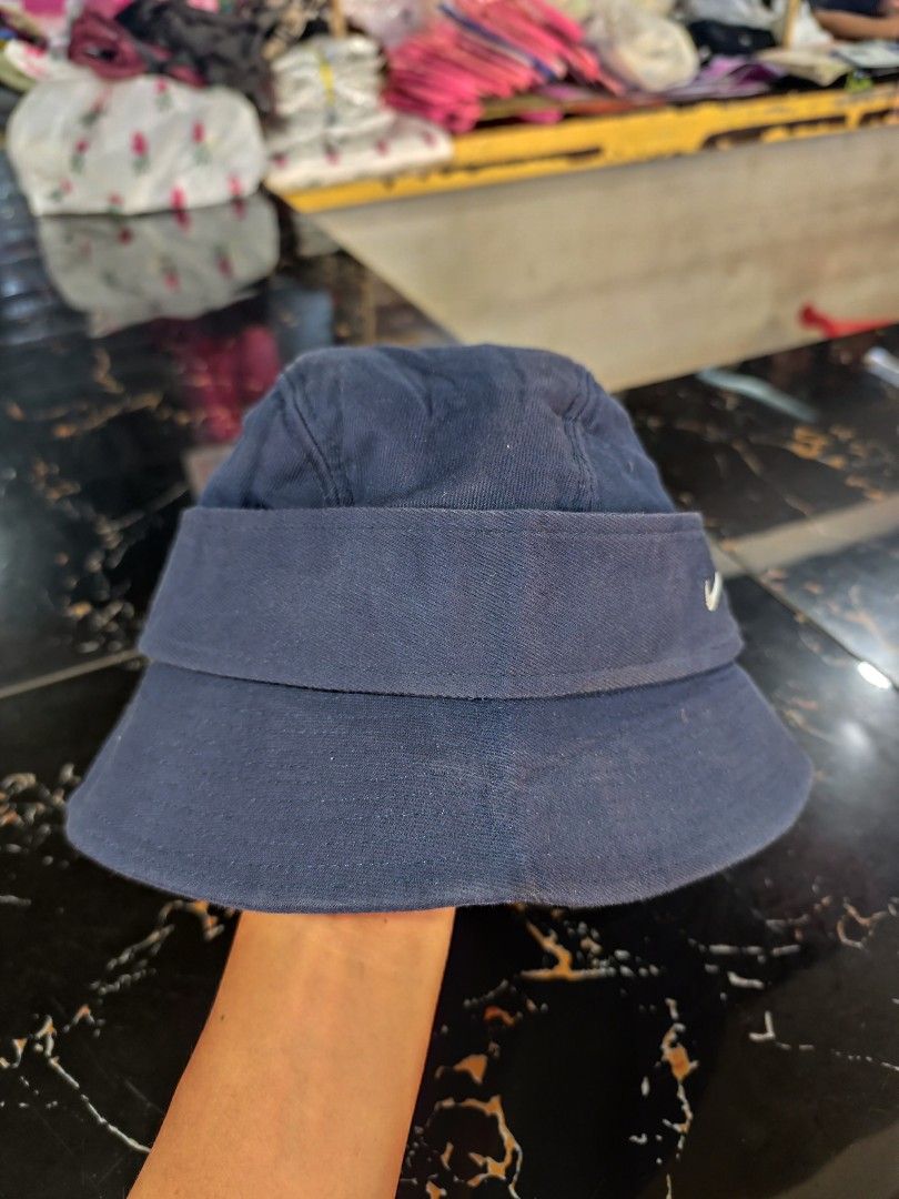 Vintage Nike Bucket Hat Size M/L (Category: Caps & Hats) located in Cordova. Submitted by bsb.streetluxvintage.clothing (Listing ID 1466974993, Image 3). Description: - Brand: Nike - Color: Navy blue - Size: M/L - Material: Cotton with satin-like quilted lining - Details: Embroidered white swoosh logo, two decorative side buttons - Condition: Clean interior - Origin: Made in China.