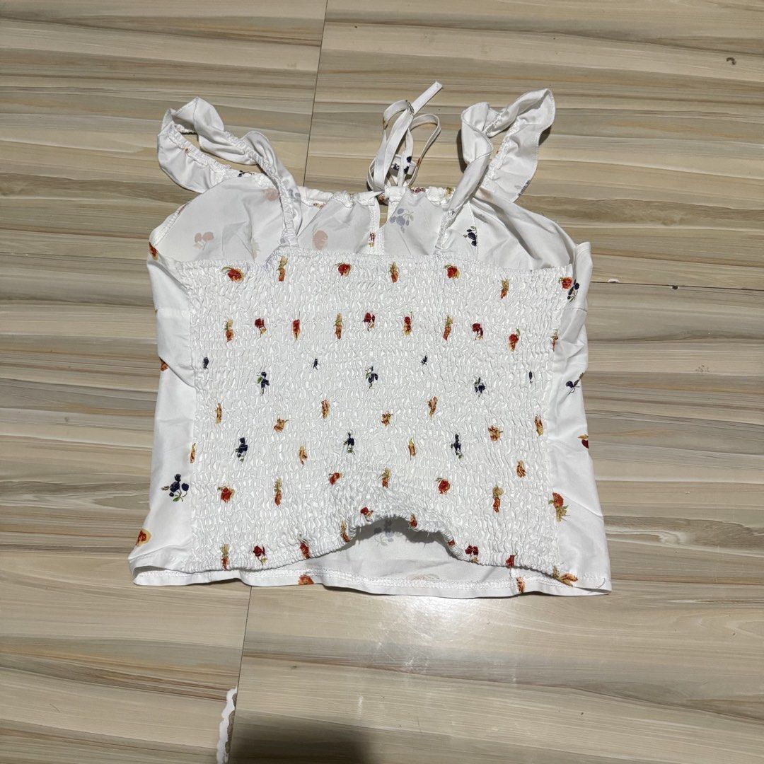 White Fruit Print Cami Tank Top (Category: Sleeveless) located in Mabalacat. Submitted by ilovegyu (Listing ID 1467165588, Image 2). Description: - L on tag. fits well on me (medium).