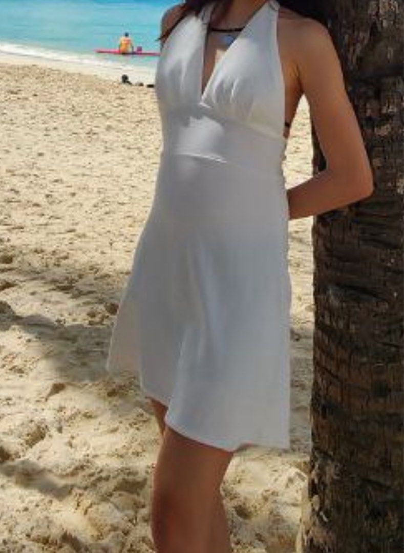 White halter neck mini dress sleeveless (Category: Dresses) located in Paranaque City. Submitted by moonbea (Listing ID 1467020882, Image 2). Description: - Style: White halter neck dress - Fit: Sleeveless with a fitted waist and flared skirt - Fabric: Lightweight and breathable - Occasion: Perfect for beach trips and sunny days out - Versatility: Easy to style with sandals or heels.