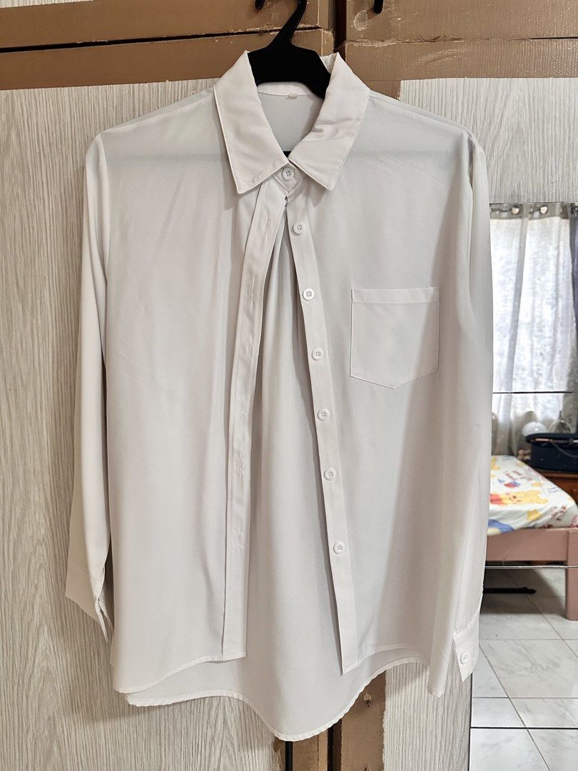 White Long Sleeve Button Down Shirt with Pocket (Category: Longsleeves) located in Paranaque City. Submitted by moonbea (Listing ID 1467044565, Image 1). Description: - Color: Classic White - Style: Long-sleeve button-down shirt with a classic collar - Details: Single left chest pocket, rounded hemline, and back center box pleat for extra comfort - Fabric: Smooth and soft texture - Versatility: Easy to style with pants or skirts for office wear o