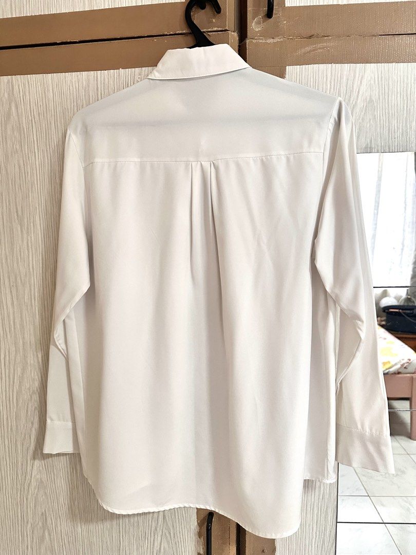 White Long Sleeve Button Down Shirt with Pocket (Category: Longsleeves) located in Paranaque City. Submitted by moonbea (Listing ID 1467044565, Image 2). Description: - Color: Classic White - Style: Long-sleeve button-down shirt with a classic collar - Details: Single left chest pocket, rounded hemline, and back center box pleat for extra comfort - Fabric: Smooth and soft texture - Versatility: Easy to style with pants or skirts for office wear o