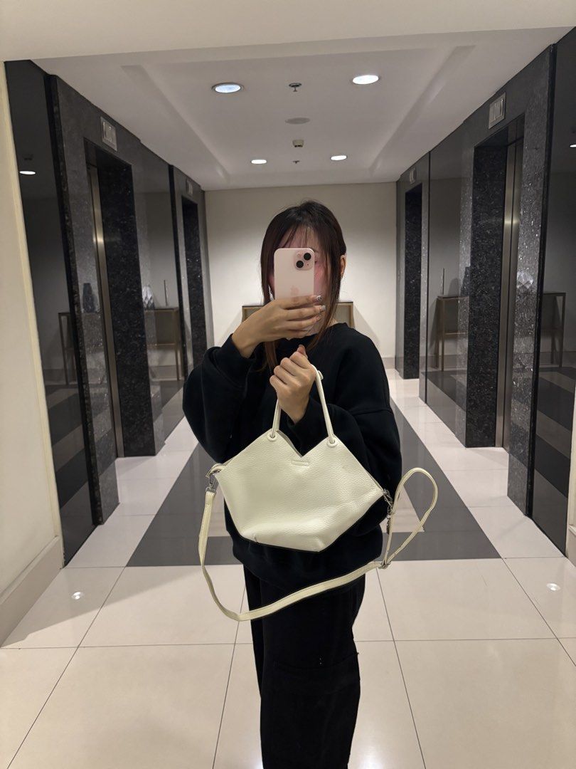 White PU Leather Tote Bag with Shoulder Strap (Category: Tote Bags) located in Makati City. Submitted by bittersweet818ta (Listing ID 1467135827, Image 3). Description: White faux leather handbag with unique petal-shaped top edge. Dual top handles plus an adjustable, detachable long shoulder strap. Includes a cute 'Love' heart charm hanging from the side zip. Main zip closure keeps items secure. Textured finish all over. Clean inside and out. Gre