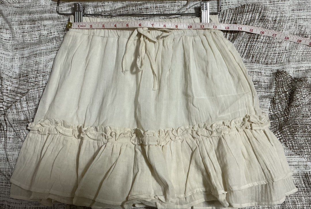 White Ruffle Tiered Mini Skort (Category: Skirts) located in Quezon City. Submitted by cleaningmomma (Listing ID 1467116399, Image 3). Description: - Color: Off White - Style: Mini skort with tiered hem ruffles - Waist: Elastic with front adjustable drawstring (11-12" across unstretched) - Length: Approx. 15 inches - Fabric: Lightweight, comfortable, cotton-like material - Condition/Vibe: Versatile and easy to mix and match for casual everyday ou