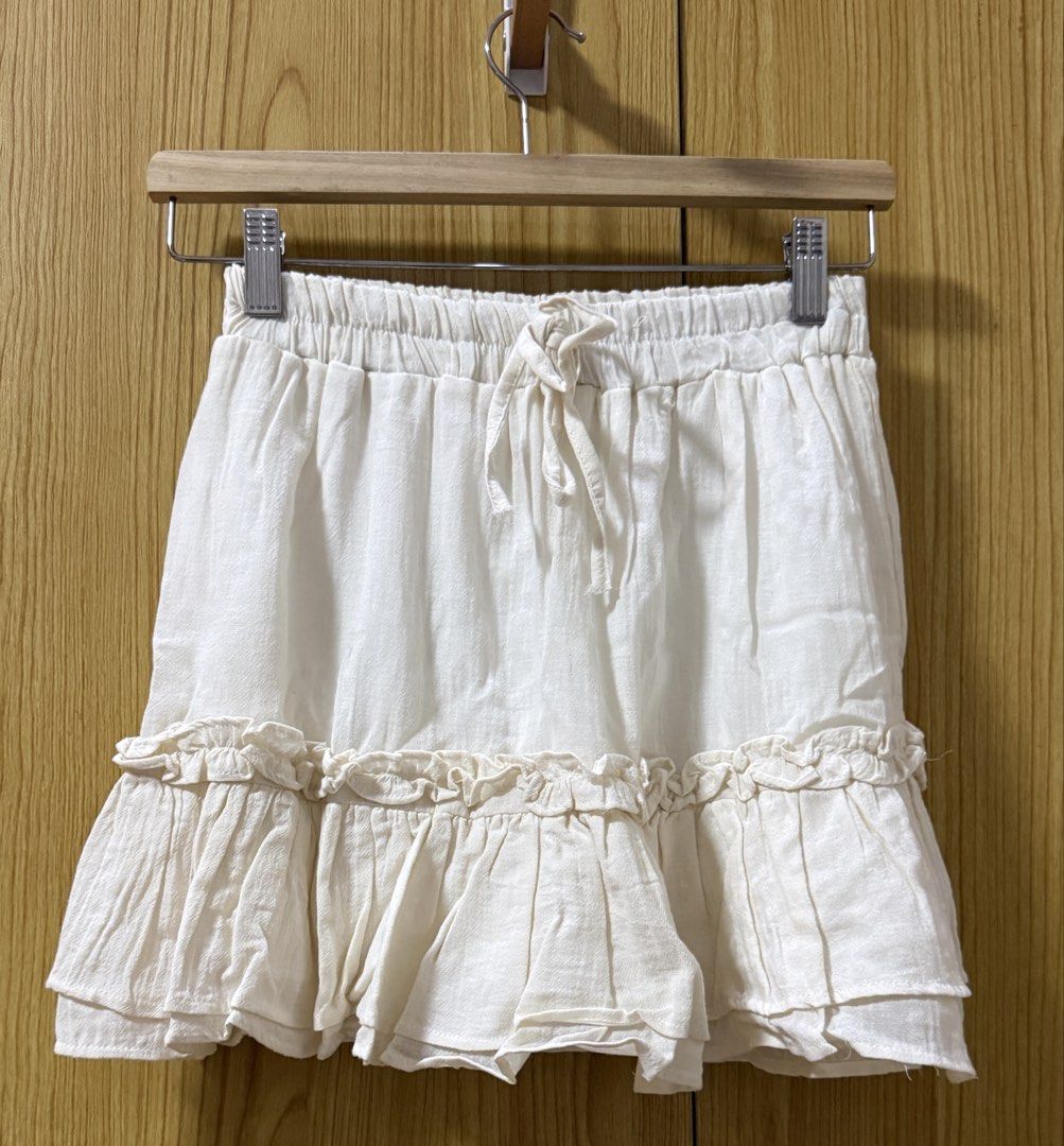 White Ruffle Tiered Mini Skort (Category: Skirts) located in Quezon City. Submitted by cleaningmomma (Listing ID 1467116399, Image 1). Description: - Color: Off White - Style: Mini skort with tiered hem ruffles - Waist: Elastic with front adjustable drawstring (11-12" across unstretched) - Length: Approx. 15 inches - Fabric: Lightweight, comfortable, cotton-like material - Condition/Vibe: Versatile and easy to mix and match for casual everyday ou
