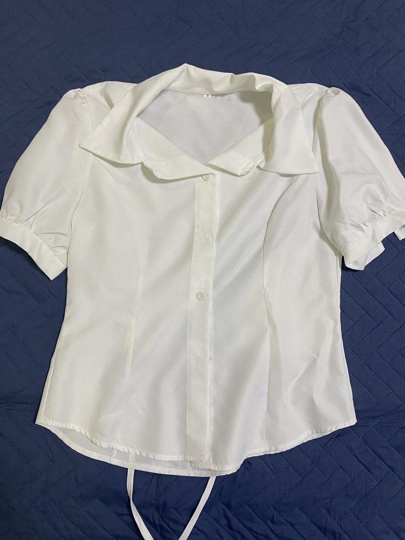 White Short Sleeve Collared Blouse with Back Tie Size S (Category: Blouses) located in Manila. Submitted by escherichiaa (Listing ID 1467140654, Image 1). Description: - Color: White - Size: S - Style: Short-sleeve button-down with classic collar - Details: Puffy sleeves and adjustable back waist tie - Fabric: Smooth, clean finish - Versatility: Ideal for casual days or office outfits.
