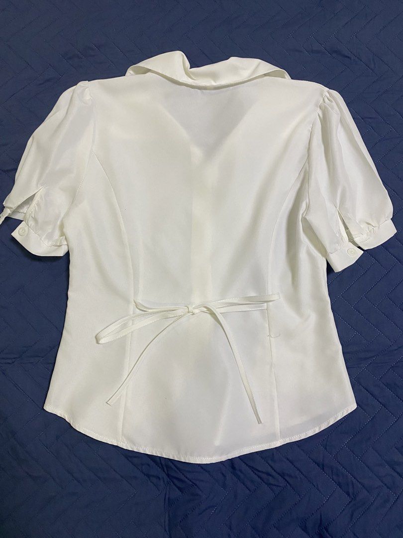 White Short Sleeve Collared Blouse with Back Tie Size S (Category: Blouses) located in Manila. Submitted by escherichiaa (Listing ID 1467140654, Image 2). Description: - Color: White - Size: S - Style: Short-sleeve button-down with classic collar - Details: Puffy sleeves and adjustable back waist tie - Fabric: Smooth, clean finish - Versatility: Ideal for casual days or office outfits.