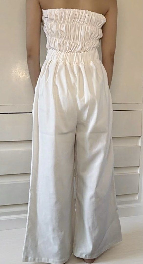 White Strapless Wide-Leg Jumpsuit (Category: Jumpsuits) located in Paranaque City. Submitted by honeykkkk (Listing ID 1467078989, Image 2). Description: • Details: Clean all-white design, structured strapless tube bodice with corseted panel seams, fitted waistband, practical side pockets, and a flattering relaxed wide-leg silhouette. • Condition: Worn a few times, with minimal flaws but in good condition. • Size: Fits XXS to S.