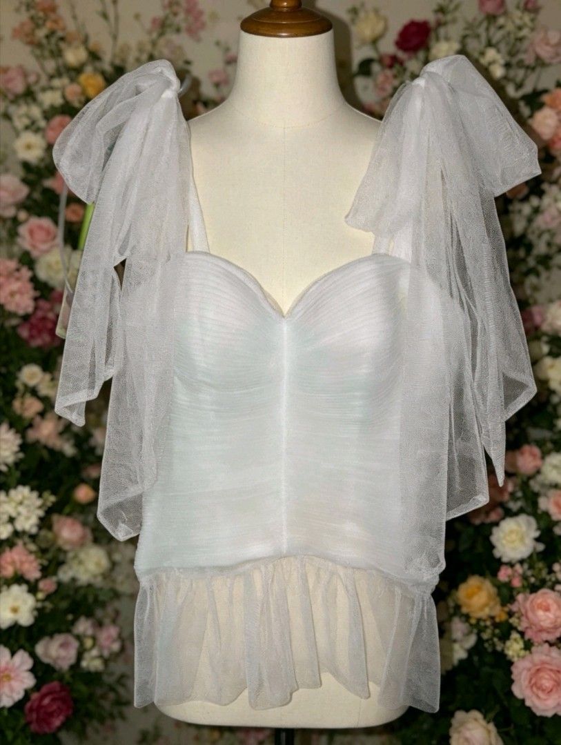 White Tulle Corset Top with Bow Straps (Category: Sleeveless) located in Manila. Submitted by charlottej01596 (Listing ID 1466983459, Image 1). Description: - Color & Style: White sheer corset top with delicate tulle ruffles and a flared hem - Design: Sweetheart neckline with structured cups and statement tulle bow shoulder straps - Versatility: Perfect for parties, dates, or dressing up your favorite denim .
