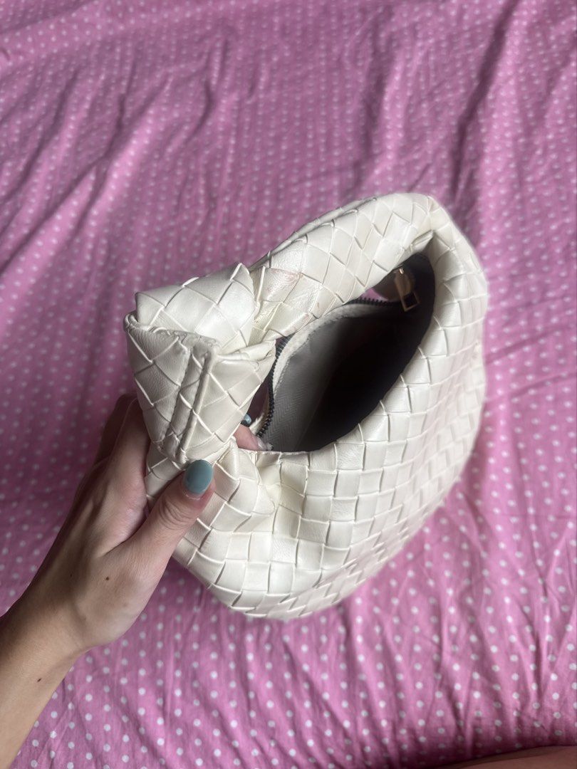 White Woven Knot Handle Shoulder Bag (Category: Shoulder Bags) located in Manila. Submitted by gkamille01 (Listing ID 1467011637, Image 2). Description: - Color & Style: White woven faux leather shoulder bag with an intrecciato pattern and trendy knotted top handle - Closure & Interior: Secure top zip closure with a spacious, fabric-lined interior - Size: Compact and practical, ideal for carrying your daily essentials - Condition: Noticeable pink