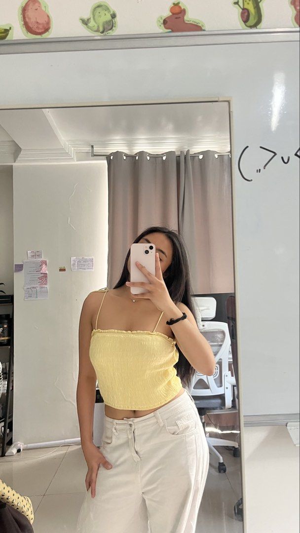 Yellow spaghetti strap crop top (Category: Sleeveless) located in Manila. Submitted by iayo.15 (Listing ID 1467062131, Image 1). Description: - Color: Bright yellow - Design: All-over smocked texture with thin spaghetti straps and straight neckline - Fit: Cropped length, stretchy and comfortable fabric - Condition: Worn once for a quick photo, practically brand new - Styling: Pairs easily with denim or white trousers.