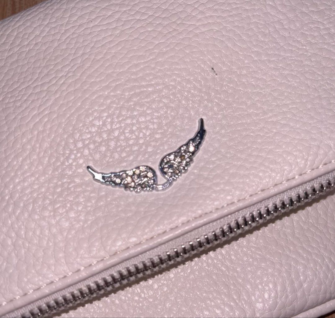 Zadig & Voltaire White Leather Rock Clutch (Category: Cross-body Bags) located in Manila. Submitted by angelinama02203 (Listing ID 1467125253, Image 3). Description: - Brand: Zadig & Voltaire - Material: White pebbled leather with silver hardware - Design: Signature crystal-embellished winged front flap - Straps: Removable woven chain and leather strap - Storage: Front zipper pocket and back zip compartment - Condition: Clean interior and exterio